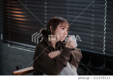 部屋着で、朝ソファーでスマホを見てリラックスしてる女性 部屋着で、朝ソファーでスマホを見てリラックスしてる女性 112279113