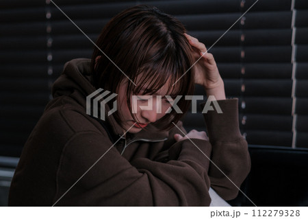 暗い部屋で落ち込んでいる女性 112279328