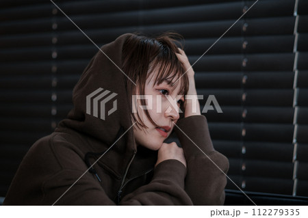 暗い部屋で落ち込んでいる女性 112279335