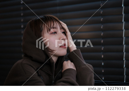 暗い部屋で落ち込んでいる女性 暗い部屋で落ち込んでいる女性 112279338