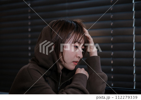 暗い部屋で落ち込んでいる女性 112279339