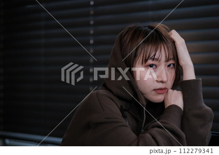 暗い部屋で落ち込んでいる女性 112279341