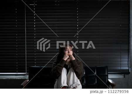 暗い部屋で落ち込んでいる女性 暗い部屋で落ち込んでいる女性 112279356