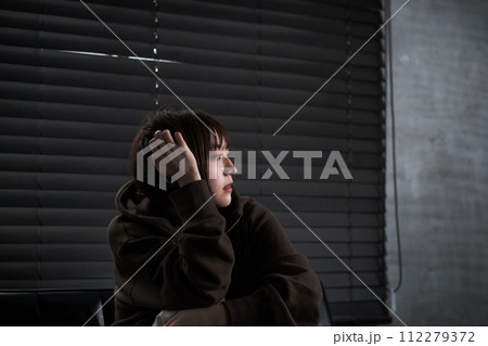 暗い部屋で落ち込んでいる女性 112279372