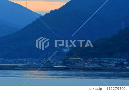 夕暮れの海辺をゆっくり走行する列車 夕暮れの海辺をゆっくり走行する列車 112279502