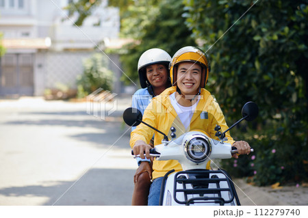 Motorbike taxi driver giving ride to happy woman Motorbike taxi driver giving ride to happy woman 112279740