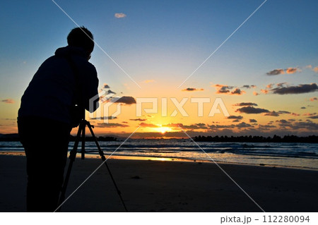 夕日を撮影するカメラマン 112280094