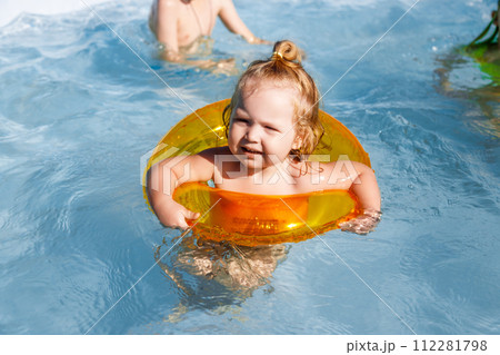 Baby girl swimming in a pool. Water park. Summer 112281798