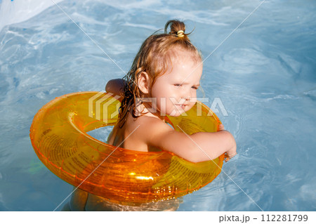 Baby girl swimming in a pool. Water park. Summer 112281799
