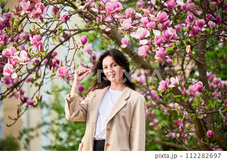 Woman allergic suffering from seasonal allergy at spring. Young happy woman showing allergy drugs, posing in blossoming garden at springtime. Antihistamine medication concept Woman allergic suffering from seasonal allergy at spring. Young happy woman showing allergy drugs, posing in blossoming garden at springtime. Antihistamine medication concept 112282697