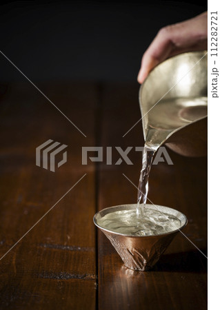 錫の酒器で注ぐ冷酒のイメージ　縦位置　4 112282721