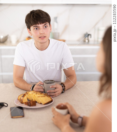 Young couple drinking tea and talking in kitchen 112283590