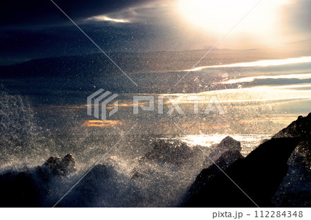 冬の夕暮れ時の海岸線と波しぶき 112284348