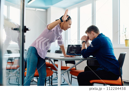 A furious business director of a startup office berating her employee for business mistakes and errors 112284438