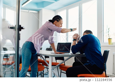 A furious business director of a startup office berating her employee for business mistakes and errors 112284556