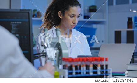 Biology scientists studying pathology in blood samples, conducting research 112284849