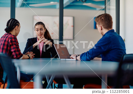 A team of successful programmers sits in a startup office, strategizing new business projects and solving existing challenges, showcasing innovation and collaboration in the tech industry 112285001