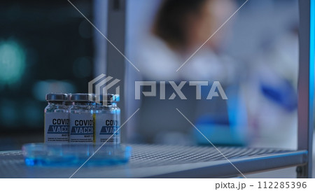 Close-up of Covid-19 vaccine bottles standing on shelf, disease prevention, vaccination 112285396