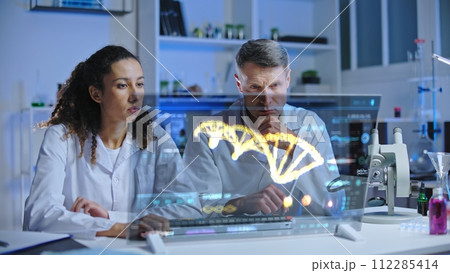 DNA scientists looking at DNA sequence on screen, puzzled with experiment results DNA scientists looking at DNA sequence on screen, puzzled with experiment results 112285414