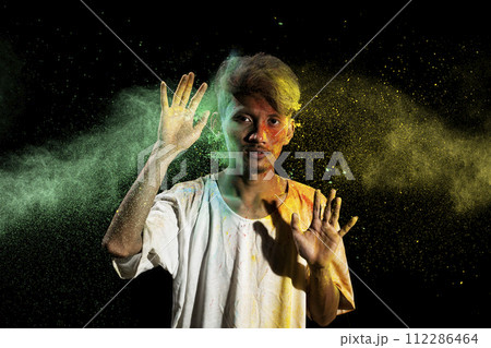 Portrait of a man celebrating Holi with colorful Holi powder 112286464