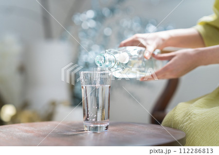 グラスに水を注ぐ グラスに水を注ぐ 112286813