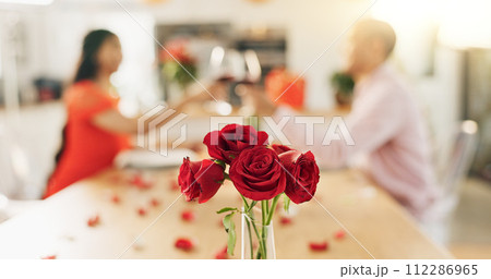 Couple, roses and toast at home with wine glass for celebration of love, romance and valentines day. People cheers for date success, drinking red champagne and luxury dinner at a table with flowers Couple, roses and toast at home with wine glass for celebration of love, romance and valentines day. People cheers for date success, drinking red champagne and luxury dinner at a table with flowers 112286965