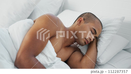 Man, resting and sleeping in bed at home, peace and dreaming or relax on sunday morning. Male person, comfortable and blanket for stress relief, lazy and house nap on soft bedding and calm on weekend Man, resting and sleeping in bed at home, peace and dreaming or relax on sunday morning. Male person, comfortable and blanket for stress relief, lazy and house nap on soft bedding and calm on weekend 112287357