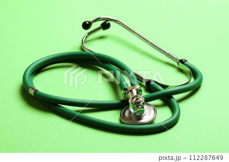 Top view of green medical stethoscope on colorful background with copy space. Medicine equipment concept 112287649