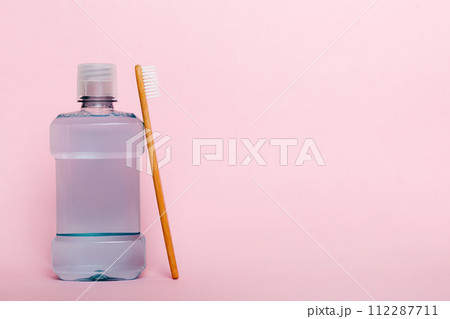 Mouthwash and other oral hygiene products on colored table top view with copy space. Flat lay. Dental hygiene. Oral care products and space for text on light background. concept 112287711