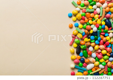 Mixed collection of colorful candy, on colored background. Flat lay, top view. frame of colorful chocolate coated candy Mixed collection of colorful candy, on colored background. Flat lay, top view. frame of colorful chocolate coated candy 112287751