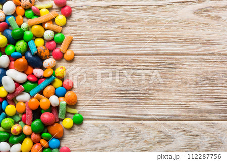 Mixed collection of colorful candy, on colored background. Flat lay, top view. frame of colorful chocolate coated candy Mixed collection of colorful candy, on colored background. Flat lay, top view. frame of colorful chocolate coated candy 112287756