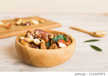 Fresh healthy Brazil nuts in bowl on colored table background. Top view Healthy eating bertholletia concept. Super foods Fresh healthy Brazil nuts in bowl on colored table background. Top view Healthy eating bertholletia concept. Super foods 112287871