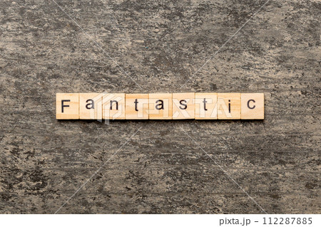 fantastic word written on wood block. fantastic text on cement table for your desing, concept 112287885