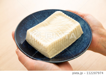 手作りの木綿豆腐のお皿を持つ女性の手元 112287974