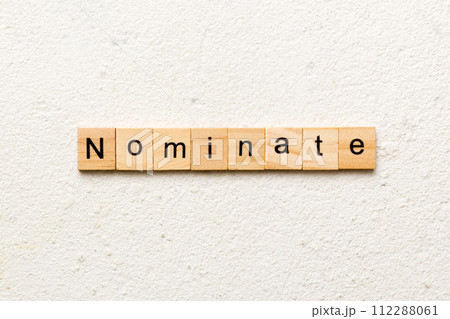 nominate word written on wood block. nominate text on table, concept 112288061