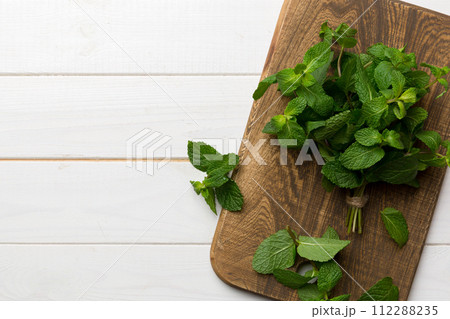 Fresh mint on Cutting board table, top view. Flat lay Space for text Fresh mint on Cutting board table, top view. Flat lay Space for text 112288235