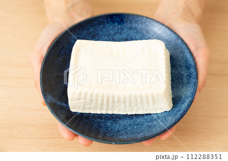 手作りの木綿豆腐のお皿を持つ女性の手元 112288351