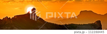 Landscape, sunset and panoramic view of mountains, Gran Canaria Island with nature skyline and environment. Orange sky, horizon and natural background with travel location or destination in Spain 112288445
