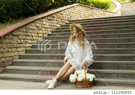 Beautiful girl with flowers on the street in summer. Beautiful girl with flowers on the street in summer. 112290095