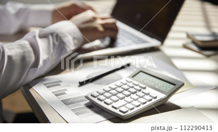 Desk with calculators for calculating, managing and analyzing economic profits and losses. 112290413