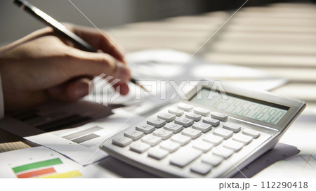 Desk with calculators for calculating, managing and analyzing economic profits and losses. 112290418