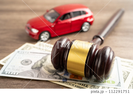 Hammer gavel judge and US dollar banknote money with car vehicle accident, insurance coverage claim lawsuit court case. 112291751
