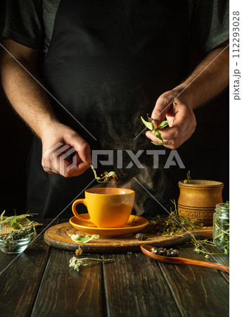 Making healthy green tea from medicinal herbs. Adding dry linden to boiling water to relieve a cold or high fever. Treatment of influenza virus Making healthy green tea from medicinal herbs. Adding dry linden to boiling water to relieve a cold or high fever. Treatment of influenza virus 112293028