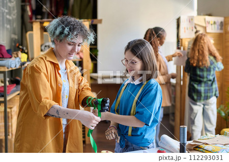 Waist up portrait of two teenage girls decorating prosthetics in inclusive crafting class Waist up portrait of two teenage girls decorating prosthetics in inclusive crafting class 112293031