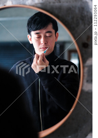 洗面台で鏡の前で歯を磨く男性 洗面台で鏡の前で歯を磨く男性 112293064