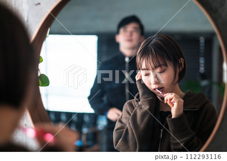 朝洗面台の鏡の前で歯を磨く女性 112293116