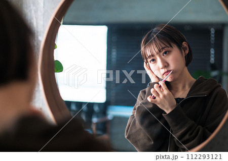 朝洗面台の鏡の前で歯を磨く女性 112293121