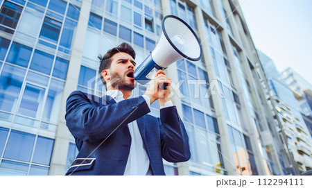 Businessman Shouting into Megaphone on the Street Businessman Shouting into Megaphone on the Street 112294111