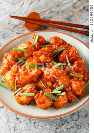 Gobi Manchurian pairs crispy cauliflower with a sweet, tangy Indo-Chinese sauce closeup on the plate. Vertical 112294784