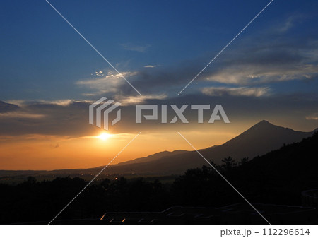 暗雲の下に出たオレンジ色の太陽と空、シルエットの磐梯山とのコントラストが印象的で綺麗だ。 112296614